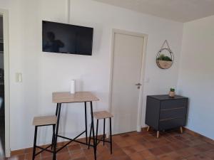 ein Zimmer mit einem Tisch und zwei Hockern und einem Fernseher an der Wand in der Unterkunft Studio in Levens