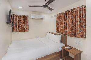 a small room with two beds and a table at Uma Residency - Chakala in Mumbai
