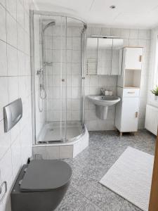 a bathroom with a shower and a toilet and a sink at Ferienwohnung AM PETER in Gotha +2 photos