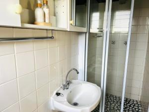 a bathroom with a white sink and a shower at Kamieskroon Hotel in Kamieskroon