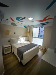 a bedroom with a bed with fish painted on the ceiling at Bossa Jurerê Hotel in Florianópolis