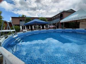 a large pool with blue water in front of a building at Comfort Guest House in Borovoye