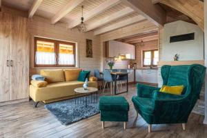a living room with a couch and chairs and a kitchen at Osada Gorczański Zakątek in Nowy Targ
