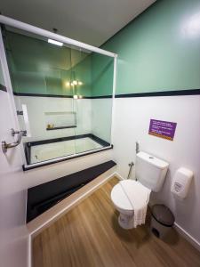 a bathroom with a glass shower and a toilet at Bossa Jurerê Hotel in Florianópolis