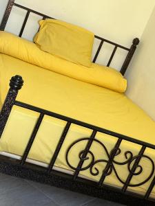 a bed with yellow sheets and a yellow pillow at White Bay Ras Sedr وايت باي راس سدر in Ras Sedr