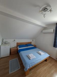 a bedroom with a bed with blue sheets and blue pillows at Guest House Matej & Mateja in Plitvička Jezera