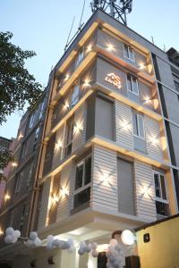 a tall building with lights on the side of it at AS Living Guest House - A boutique stay near Apollo Hospital, City Center Mall, PhysicsWallah, Allen, SPM in Guwahati