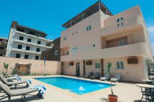 a villa with a swimming pool in front of a building at Luxor Guest House in Luxor