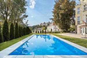 a swimming pool in the yard of a house at Akropolis Apart Hotel in Karlovy Vary