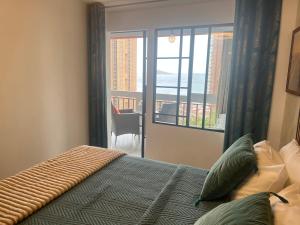 a bedroom with a bed with a view of a balcony at BENILOVE en playa VUE MER Panoramique in Benidorm