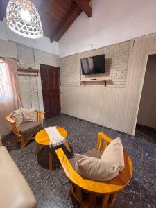 a living room with a tv and a table and chairs at Casa en Berazategui in Plátanos