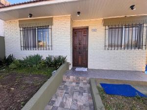 a house with a wooden door and wrought iron gates at Casa en Berazategui in Plátanos