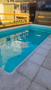 a swimming pool with blue water in a building at Casa en Berazategui in Plátanos