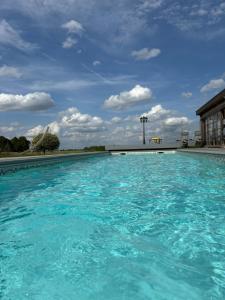 a large pool of blue water in front of a building at B&B Les Autres Sens in Villers-la-Ville +8 photos
