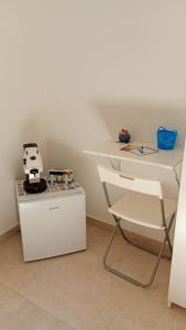 a white desk and a chair next to a table at La Corte Dei Naviganti in Trapani