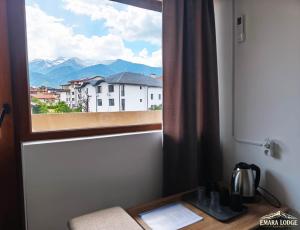 a window with a view of a city and mountains at Emara Lodge Bansko in Bansko