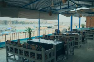 a restaurant with tables and chairs with a view of the water at Luxor Guest House in Luxor