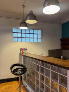 a bar in a restaurant with a stool and lights at Hostel rivendell lima in Lima +29 photos