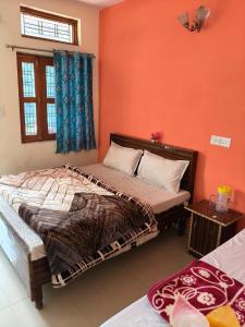 a bedroom with a large bed with orange walls at Hotel B M AND SONS in Phata