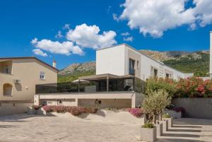 a white house with mountains in the background at Villa Sunset with swimming pool in Baška