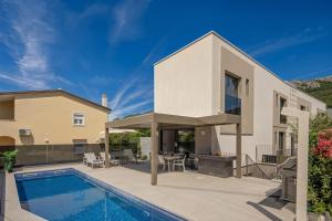 a villa with a swimming pool and a house at Villa Sunset with swimming pool in Baška