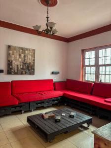 a living room with red couches and a table at Hostel rivendell lima in Lima
