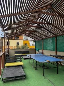 a ping pong table and benches under a pergola at Hostel rivendell lima in Lima