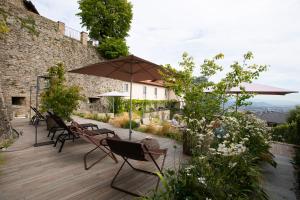 a wooden deck with chairs and an umbrella at Relais San Vigilio al Castello in Bergamo
