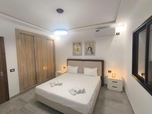 a bedroom with a white bed with two towels on it at Prestige Pool Retreat in Hammamet