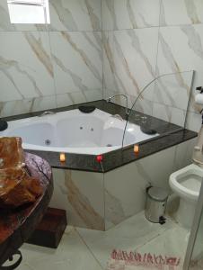 a bathroom with a bath tub and a toilet at Pousada Canto do Sossego in Brumadinho