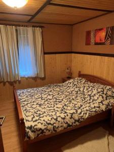 a bedroom with a bed in a room with a window at cozy alpine house in Breitenstein