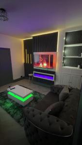a living room with a couch and a tv at GS Maisons Hideaway in Sheffield