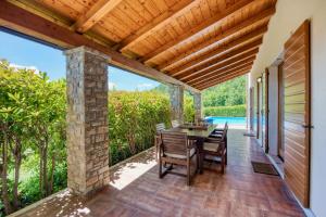 a dining room with a table and chairs on a patio at Villa Dol in Buzet