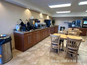 a restaurant with a table and chairs and a kitchen at Best Western Clifton Park in Clifton Park
