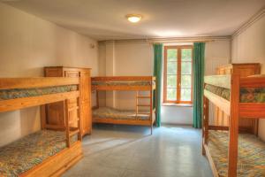 a room with three bunk beds and a window at Gite d'Etape Ascou La Forge in Ascou