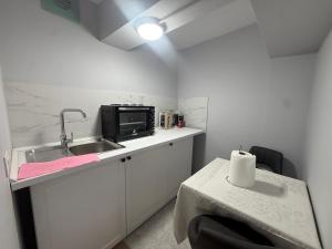 a small kitchen with a sink and a microwave at Prime Location - shared Bath in Tirana