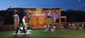 a woman standing in front of a gazebo at night at Casa Verde in Vrîncioaia Negrileşti