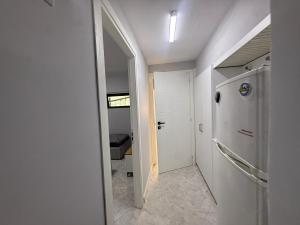 a hallway with a white refrigerator and a door at Prime Location - shared Bath in Tirana