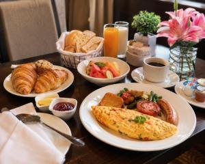 a table with plates of breakfast food on it at Hotel Krone International in Gurgaon