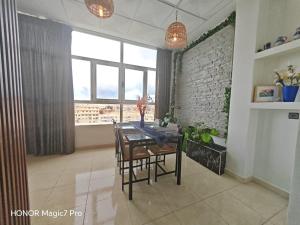 a dining room with a table and a large window at Ouida App in Oujda