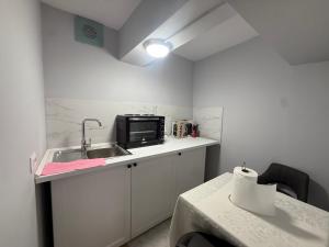 a small kitchen with a sink and a microwave at Prime Location - shared Bath in Tirana +22 photos