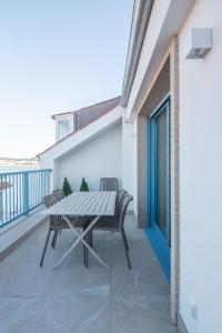 a patio with a table and chairs on a balcony at Apartamentos Turísticos A Mariña Do Carril in Vilagarcia de Arousa