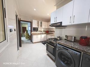a kitchen with a stove and a washer and dryer at Ouida App in Oujda