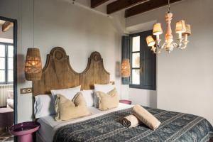 a bedroom with a large bed with a wooden headboard at Villa Station by Cassai in Ses Salines +73 photos