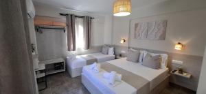 a white room with two beds and a window at House Kiriaki in Sarti