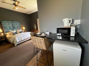 a room with a bed and a kitchen with a microwave at Kamieskroon Hotel in Kamieskroon +37 photos