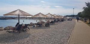a group of people sitting on a beach with umbrellas at Apartment with parking in Dajla +9 photos