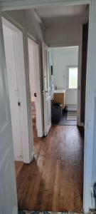 an empty room with a hallway with wooden floors at Appartement T2 Proche du CH d'Arras in Sainte-Catherine