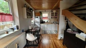 a kitchen with a table and a desk in a room at Malinowa Chatka Mostki in Mostki +37 photos