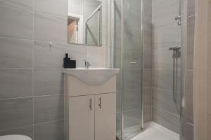 a white bathroom with a sink and a shower at Modern 3 Bed Flat - 3 En-Suites - Parking - near Wembley in Edgware +21 photos